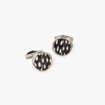 Two silver studs featuring a distinctive inlaid black and white feathers with a spotted pattern, designed to complement a classic black tuxedo ensemble with a touch of unique elegance.