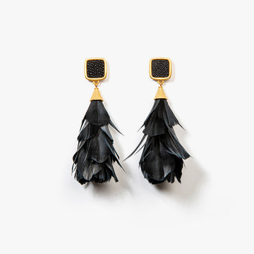 Parades earrings, designed with cascading black goose feathers beneath a gold-tone square studded top, creating a dramatic and sophisticated statement suitable for formal events.