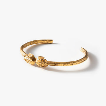 Distinctive 'Telson' cuff bracelet inspired by the horseshoe crab, crafted in textured gold, with two detailed crab shells at the center, embodying a unique blend of natural history and contemporary fashion.