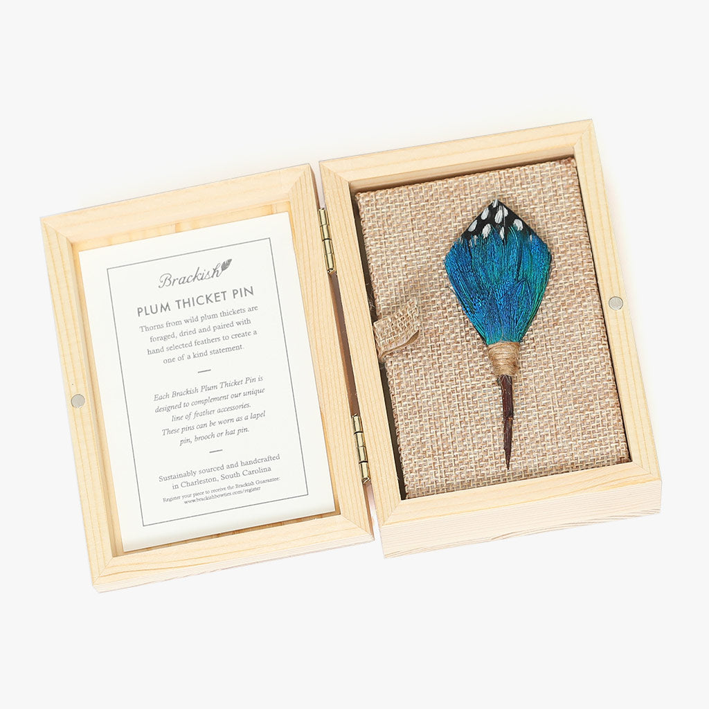 http://brackish.com/cdn/shop/products/twilight-blue-feather-plum-thicket-lapel-pin-boxed.jpg?v=1656102953