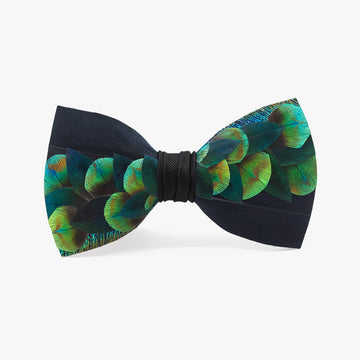 The Fairbanks men's bow tie features emerald green peacock feathers laid diagonally in an effervescent pattern with a deep navy background. 